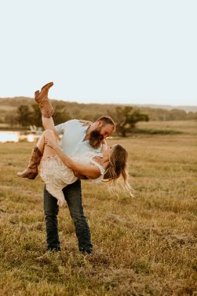 Couple dipping and kissing in a field