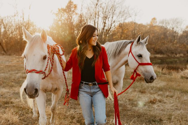 Woman in red with two white horses