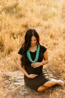 Maternity portrait in a golden field with turquoise necklace