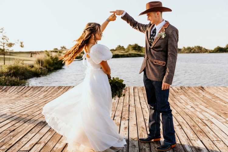 Bride twirling with groom on a dock at sunset, Oklahoma wedding photography by Taylor McClain