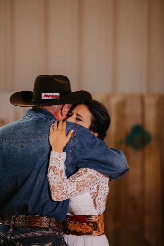 Emotional hug between bride and her father at a western wedding