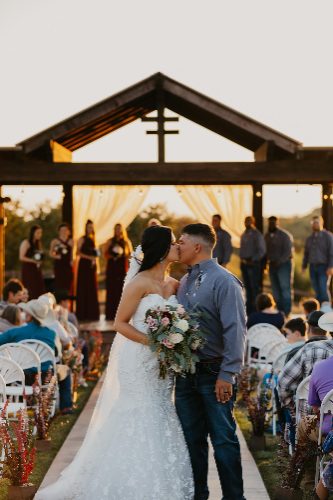 Outdoor wedding ceremony under a wooden arbor
