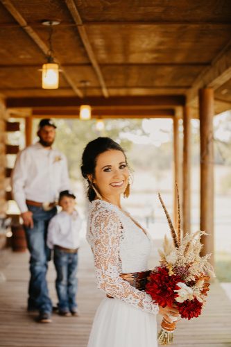 Bride with groom and ring bearer on a covered porch